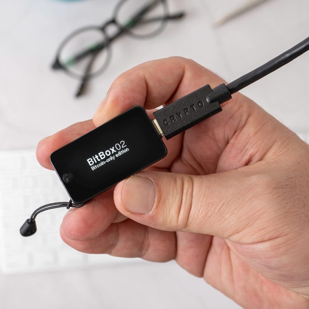 A Male Hand Holding a BitBox02 Crypto Hardware Wallet
